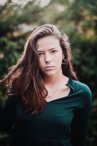 Portrait of teenage girl standing against plants