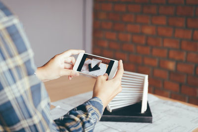 Midsection of man using mobile phone