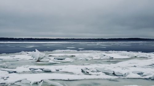 Frozen sea against sky during winter