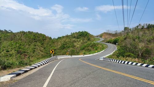 Road amidst trees against sky