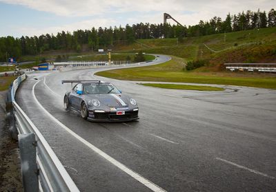 Vehicles on road against cloudy sky