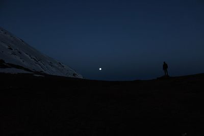 Silhouette people on land against sky at night