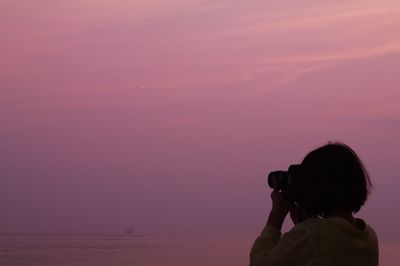 Woman looking at sea at sunset