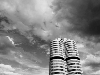 Low angle view of modern building against cloudy sky