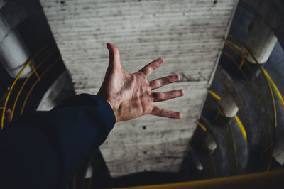 Cropped hand of man reaching ceiling