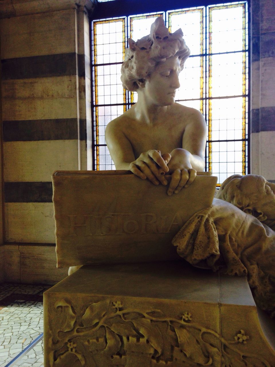 CLOSE-UP OF MAN SITTING ON SCULPTURE