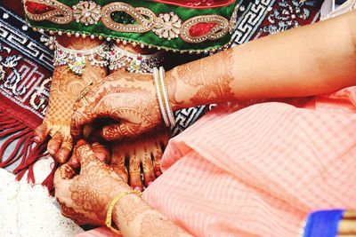 Cropped image of women with henna tattoo during event