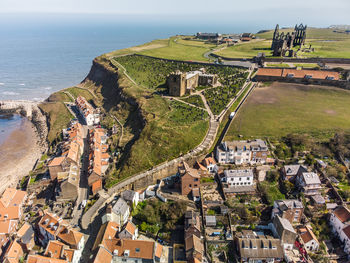 High angle view of townscape by sea against sky