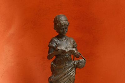 Close-up of statue against orange wall