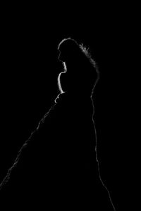 Silhouette woman standing against black background