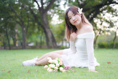 Portrait of young woman sitting on field