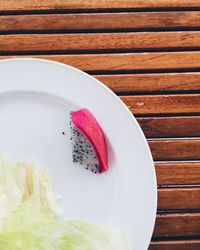 Dragon fruit slice in plate on wooden table