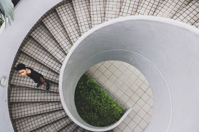 High angle portrait of young man standing on spiral staircase