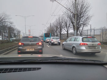 Cars on road against sky in city