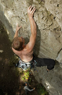 Young man climbing limestone cliff in north germany