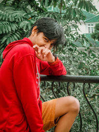 Side view of man looking away while sitting outdoors