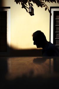 Portrait of silhouette man standing against wall