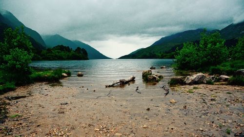 Idyllic view of calm lake against cloudy sky