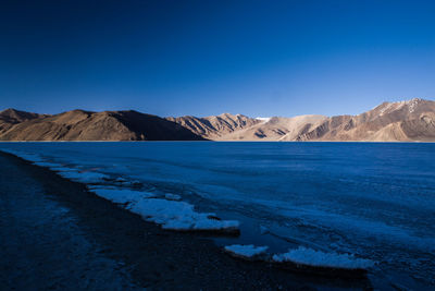 Scenic view of mountain against blue sky