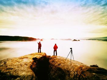 People just taking pictures, tourists on viewpoint with view to the misty mountain in morning.