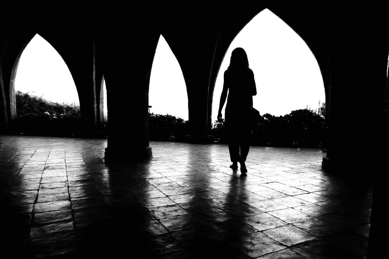 REAR VIEW OF SILHOUETTE WOMAN WALKING ON CORRIDOR