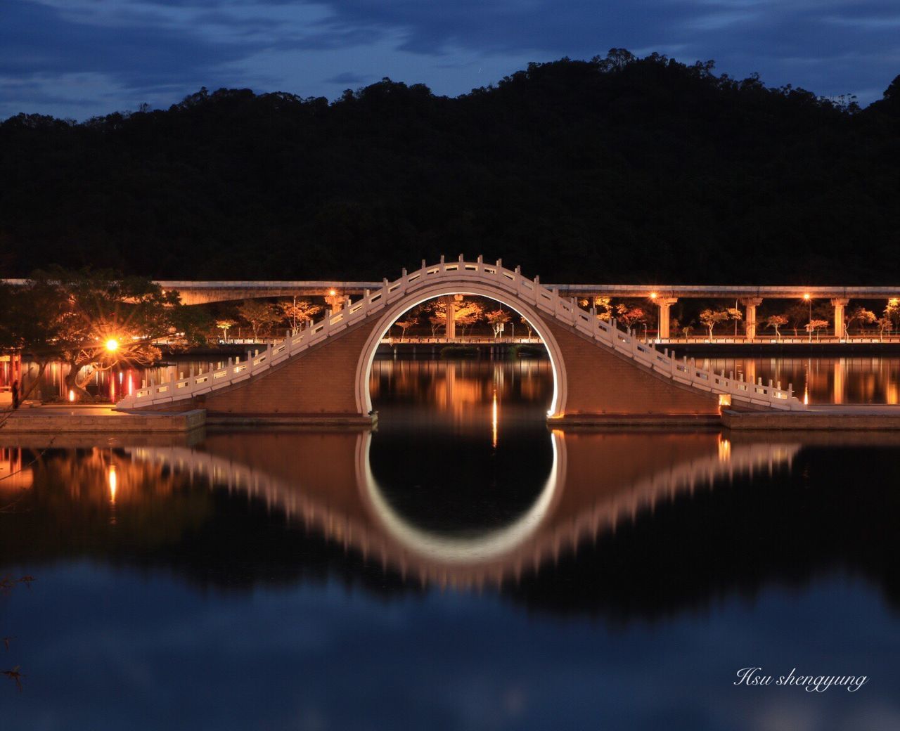 reflection, night, illuminated, water, outdoors, bridge - man made structure, vacations, arch, tree, beauty in nature, sky, no people, architecture, nature