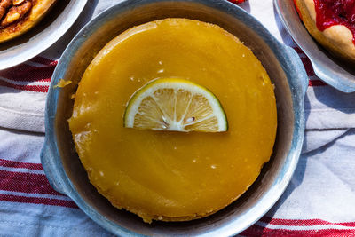 Above view of artisan baked lemon custard tart garnished with fresh lemon slice 