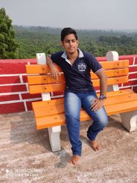 Portrait of young man sitting on bench