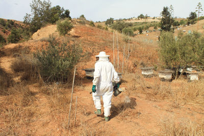 Rear view of a man walking on landscape