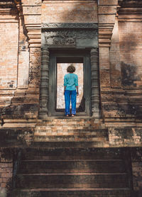 Rear view of mid adult woman standing outside ankor wat temple