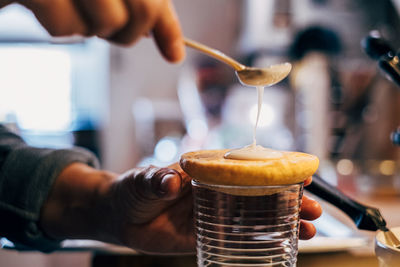 Close-up of hand pouring drink in glass