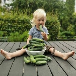 Boy is eating cucumber.