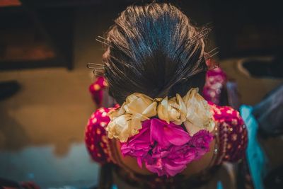 Close-up of woman with pink flower