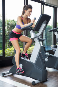 Full length woman exercising at gym