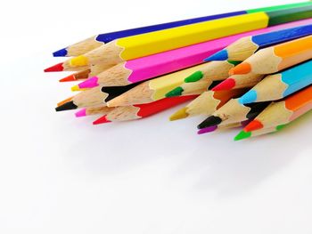 High angle view of multi colored pencils on white background
