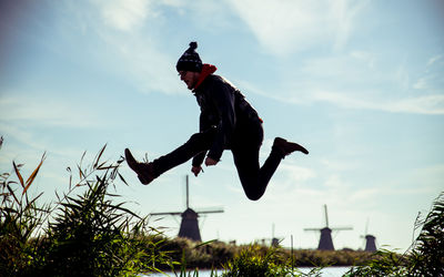 Low angle view of jumping against trees on field