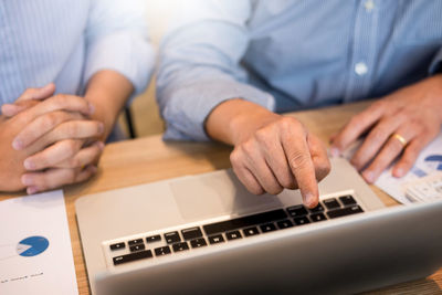 Close-up of people sitting on table