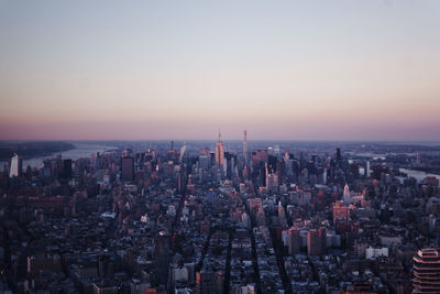 Aerial view of buildings in city at sunset