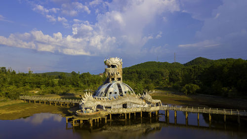 View of sculpture in lake against cloudy sky