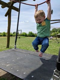 Full length of boy playing on play equipment at field