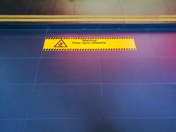 Yellow arrow symbol on tiled floor