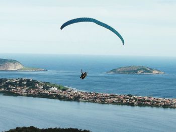 Rear view of person paragliding above sea