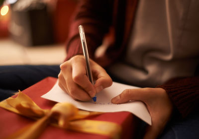 Midsection of woman writing in book