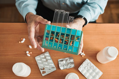 Senior man organizing his medication into pill dispenser. senior man taking pills from box