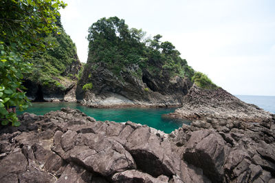 Rocks by sea against sky