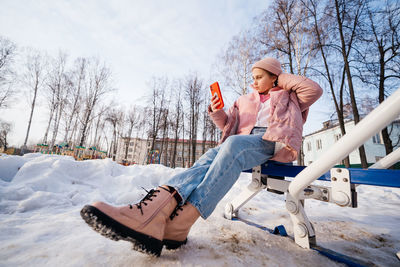 Zoomer girl uses smartphone selfie spring sunny day