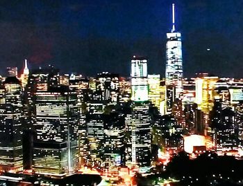 Illuminated buildings in city against sky at night