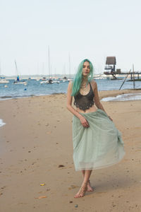 Full length portrait of young woman on beach