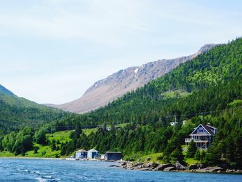 Scenic view of lake by mountains against sky