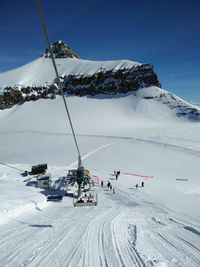 People skiing on snowcapped mountain against sky